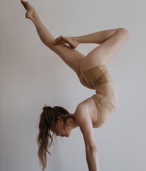 Athlete performing a challenging balance yoga pose in a calm studio.
