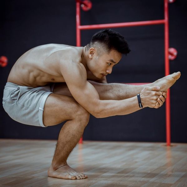 Man holding a strong yoga pose, demonstrating physical strength and focus.